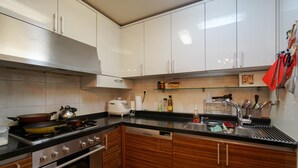 Een moderne keuken met roestvrijstalen apparatuur, houten kastjes en een zwart aanrecht.
