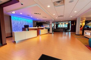 A hotel lobby with a reception desk, a seating area, and a bar. - Fairfield Inn & Suites by Marriott Atlanta Woodstock (Woodstock)