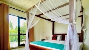 A room with a four-poster bed, a teal bedspread, and sheer curtains. - Organic Garden Sigiriya (Avudangawa)