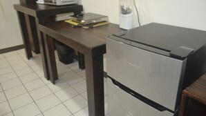 Una cucina compatta con frigorifero in acciaio inossidabile, forno a microonde e un piccolo piano di lavoro.