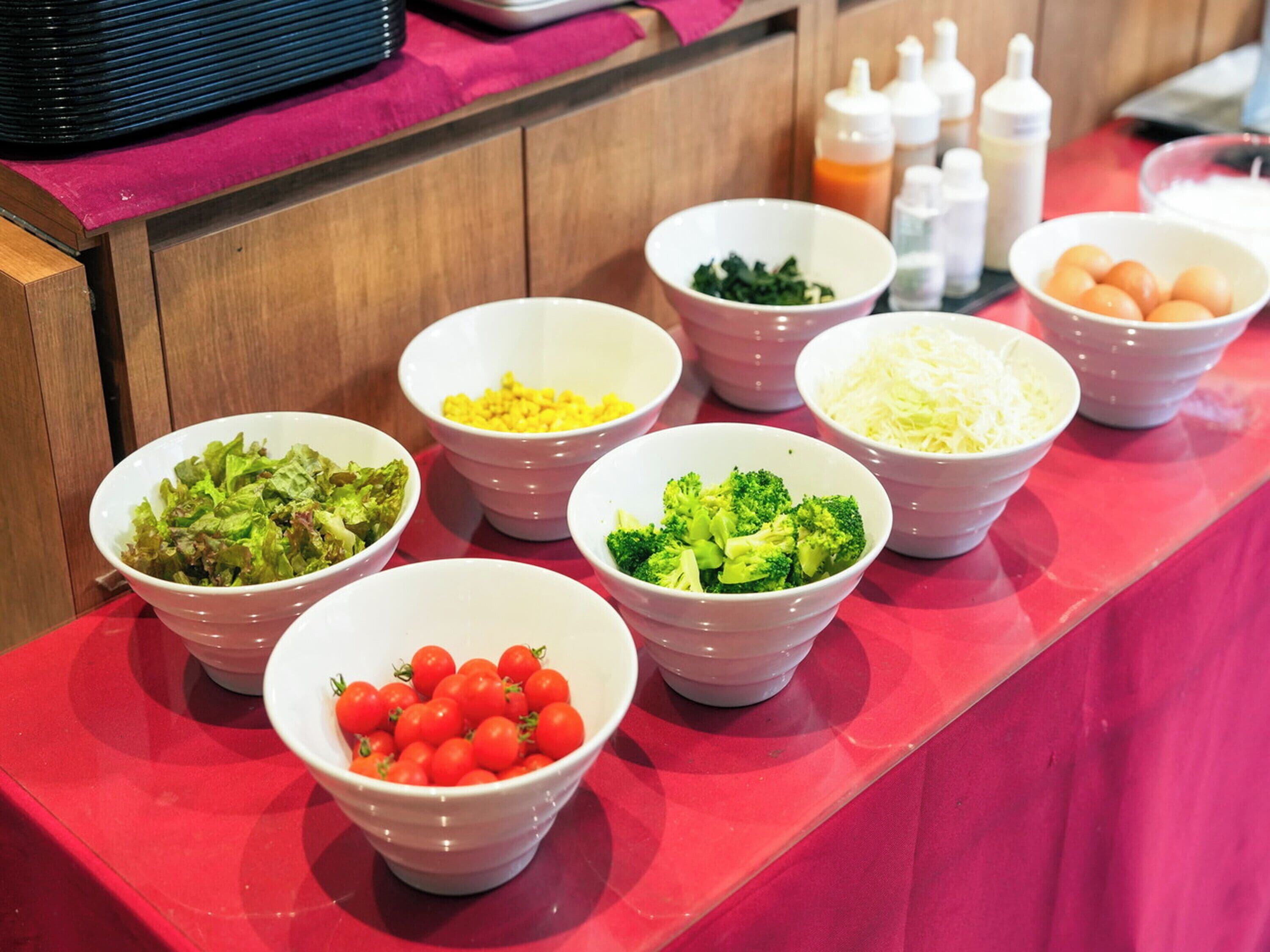 Una mesa de buffet con diversos alimentos en recipientes.
