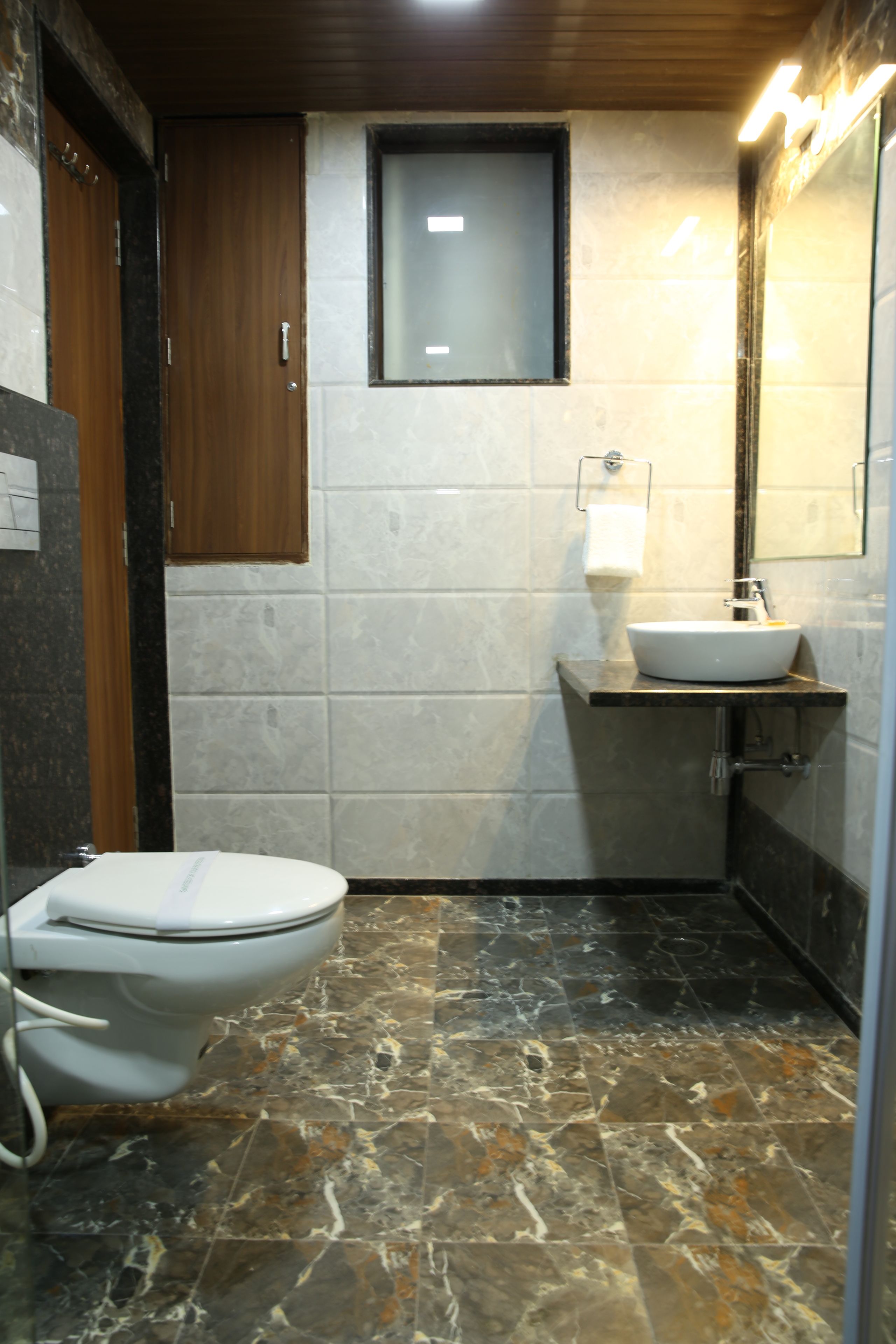 Ein kleines Badezimmer mit Toilette, Waschbecken und Spiegel.