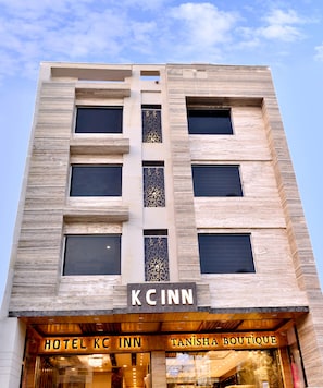 Un bâtiment d’hôtel à la façade moderne, sur lequel on peut voir une grande enseigne « KC INN » au-dessus de l’entrée.