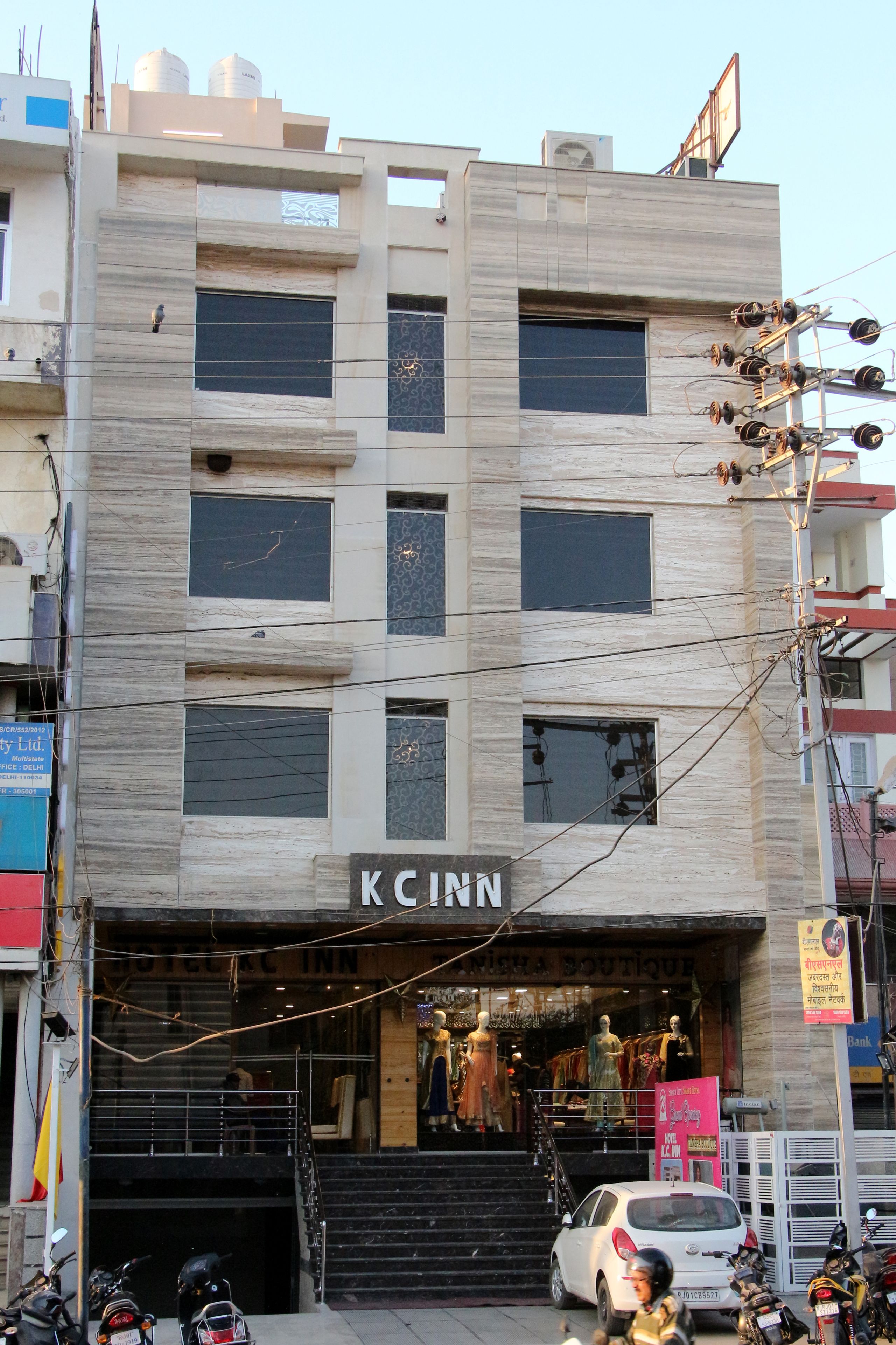 A building with a sign reading "KCINN" at the ground level, featuring a staircase leading to the entrance.
