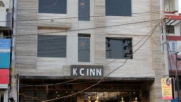 A building with a sign reading "KCINN" at the ground level, featuring a staircase leading to the entrance.