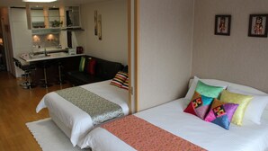 Une chambre d’hôtel avec deux lits, une kitchenette, un coin repas et une salle de bain.