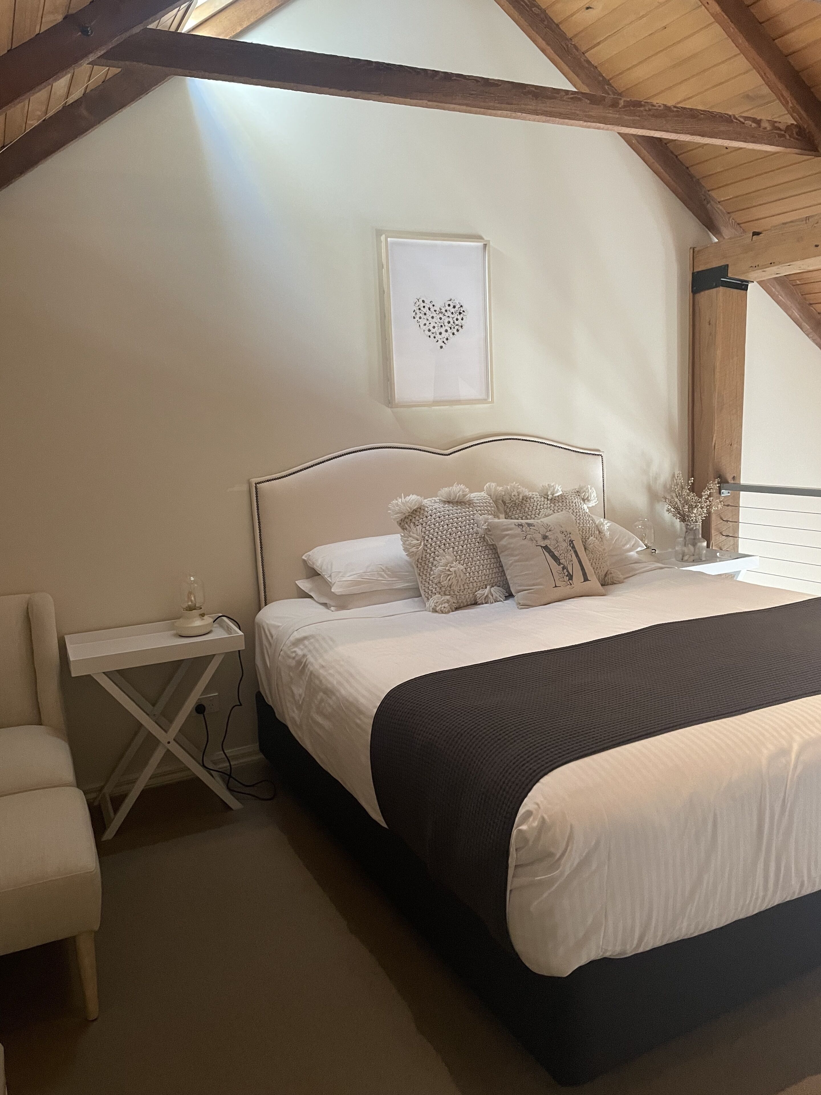 Quarto com cama, mesa de cabeceira e uma cadeira.