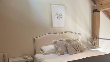 Quarto com cama, mesa de cabeceira e uma cadeira.