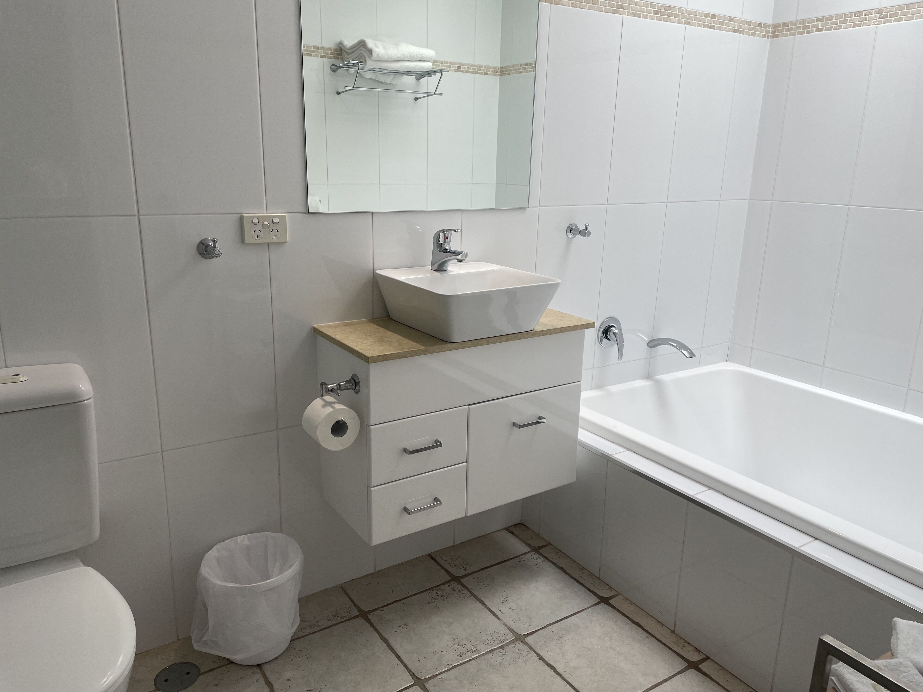 Ein modernes Badezimmer mit Toilette, Waschbecken, Waschtisch und Badewanne.