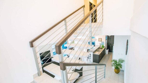 Een modern interieur met een trap, een keuken en een woongedeelte.