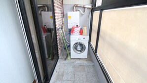 A narrow laundry room with a washing machine, a dryer, and a water heater. - Gangnam Rodem (Seoul)
