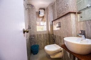 A bathroom with a toilet, sink, and shower area.