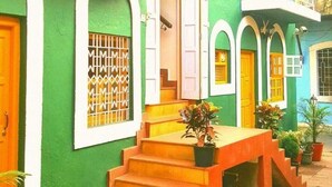 A multi-story building with green walls, orange steps, and white railings. - Marquito's Guest House (Panaji)