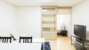 A modern living room with a sofa, TV, and built-in shelving unit. - Galleria Palace 2 (Seoul)