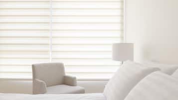 Una habitación de hotel con una cama, una silla y una lámpara.