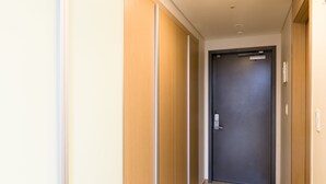 A hallway with wooden paneling on the walls and a dark door at the end. - Galleria Palace 2 (Seoul)
