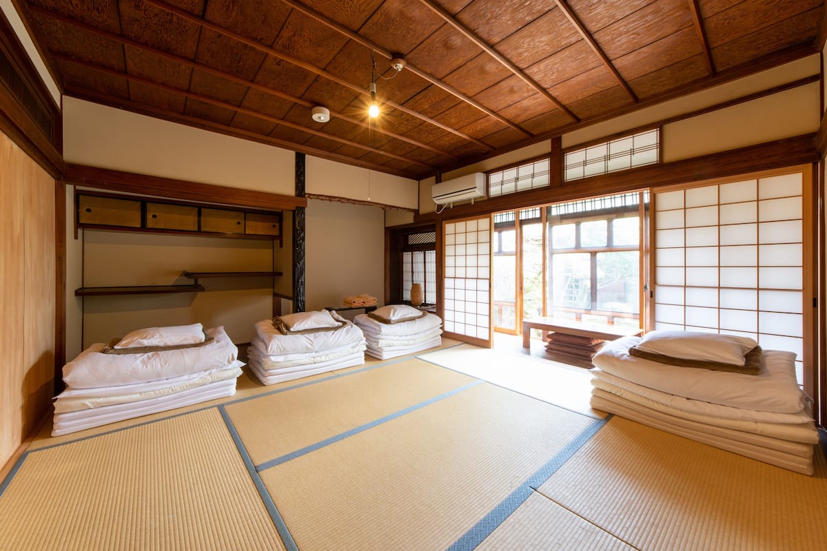 A traditional Japanese room with tatami flooring, wooden beams, and shoji screens.