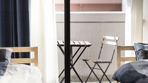 Una habitación con una cama, una silla de madera y una mesita.