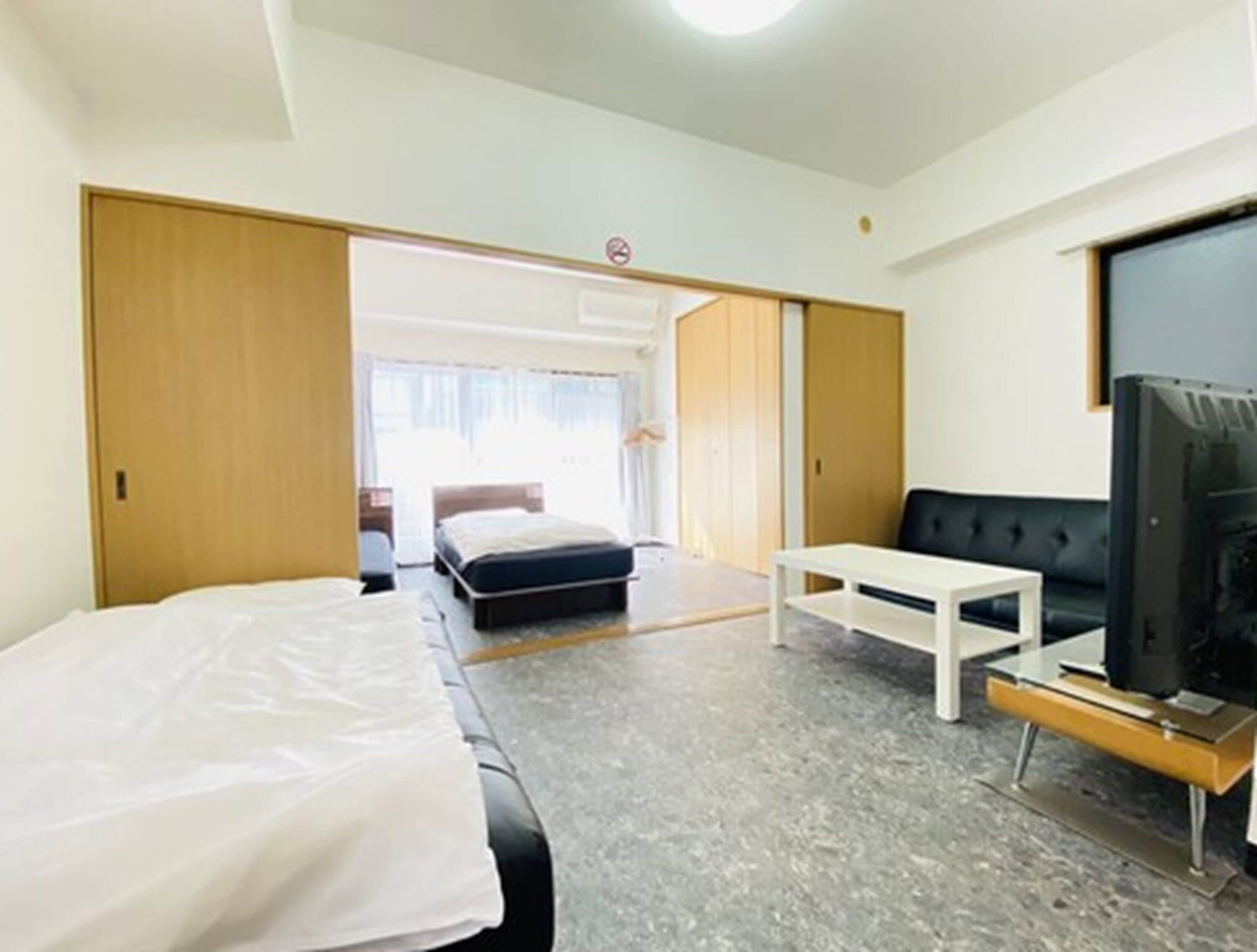 Une chambre d’hôtel avec un lit, une télévision, une petite table et une armoire.