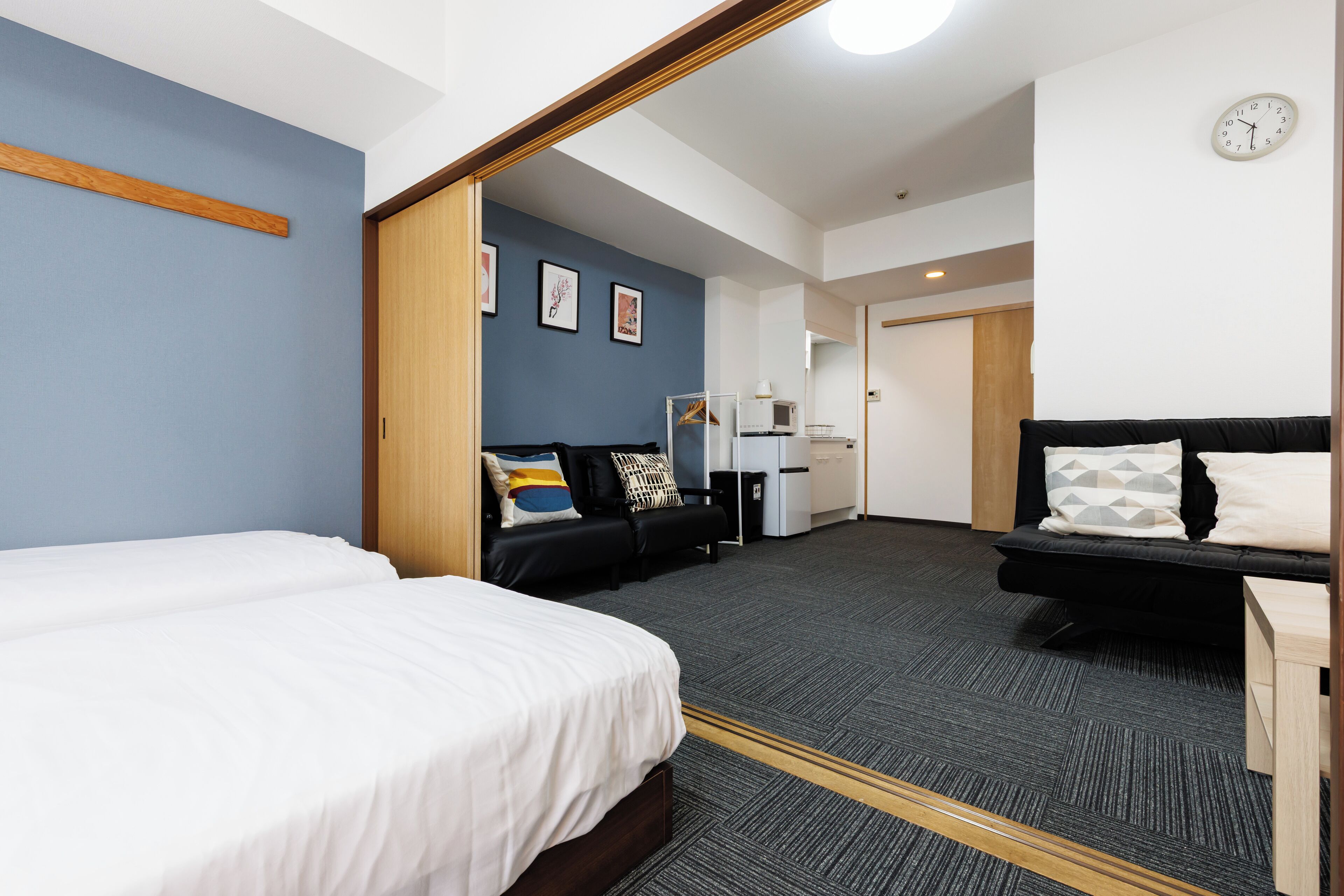 Habitación de hotel con una cama grande, un sofá y un escritorio. Hay un microondas y un refrigerador en la habitación.