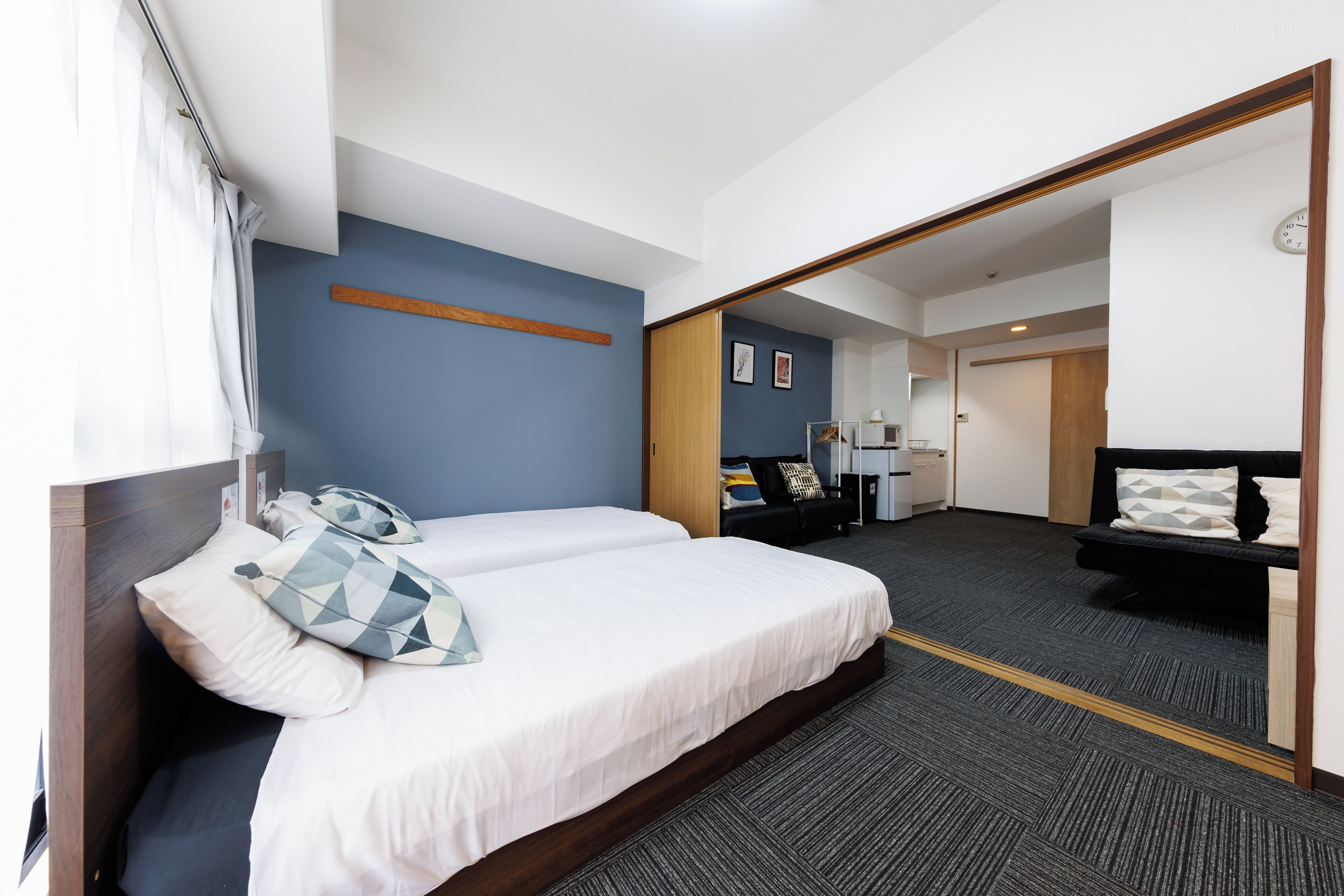 Hotellihuone, jossa on suuri sänky, työpöytä ja peili.