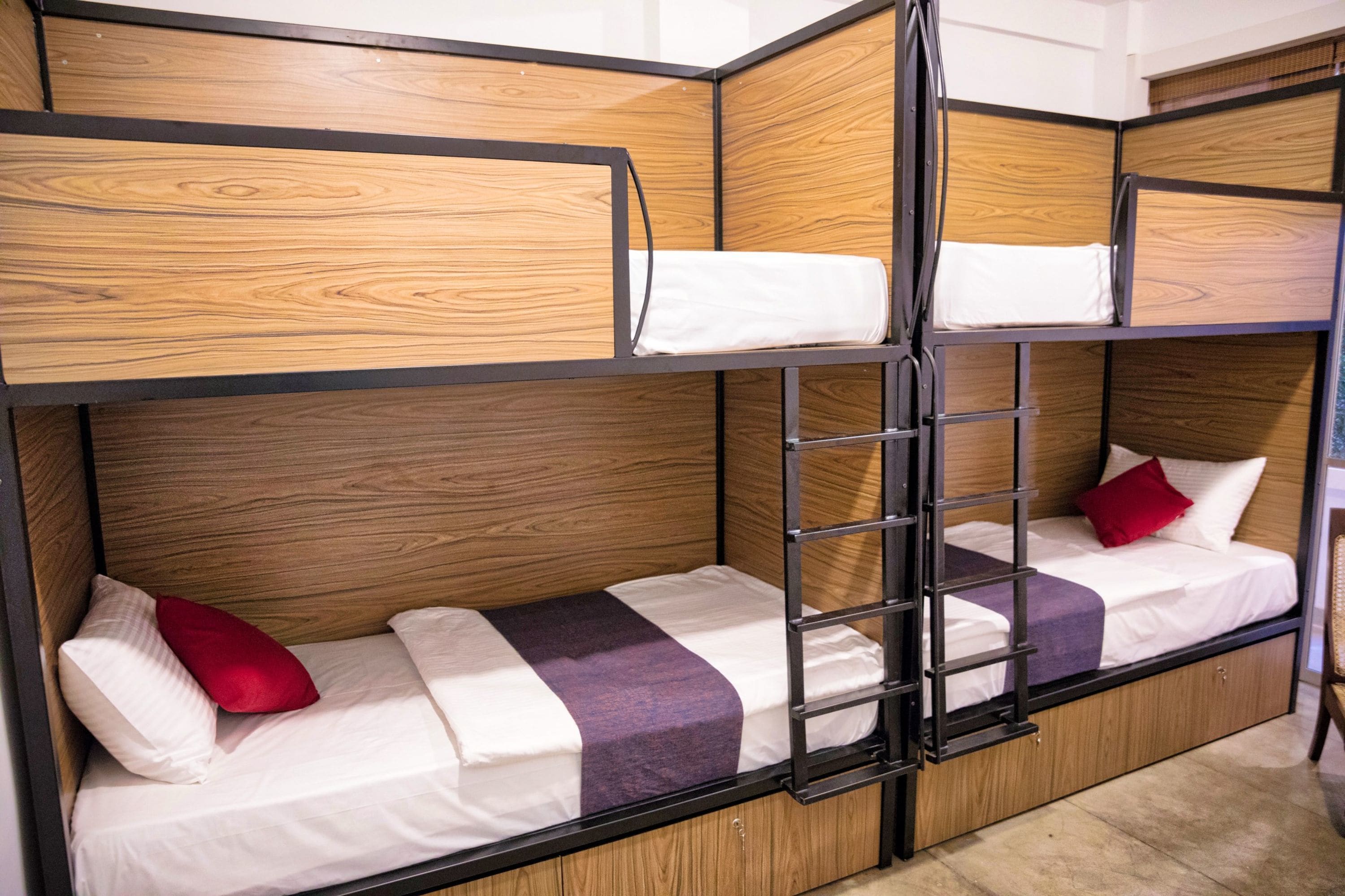 A bunk bed room with wooden paneling and metal railings.