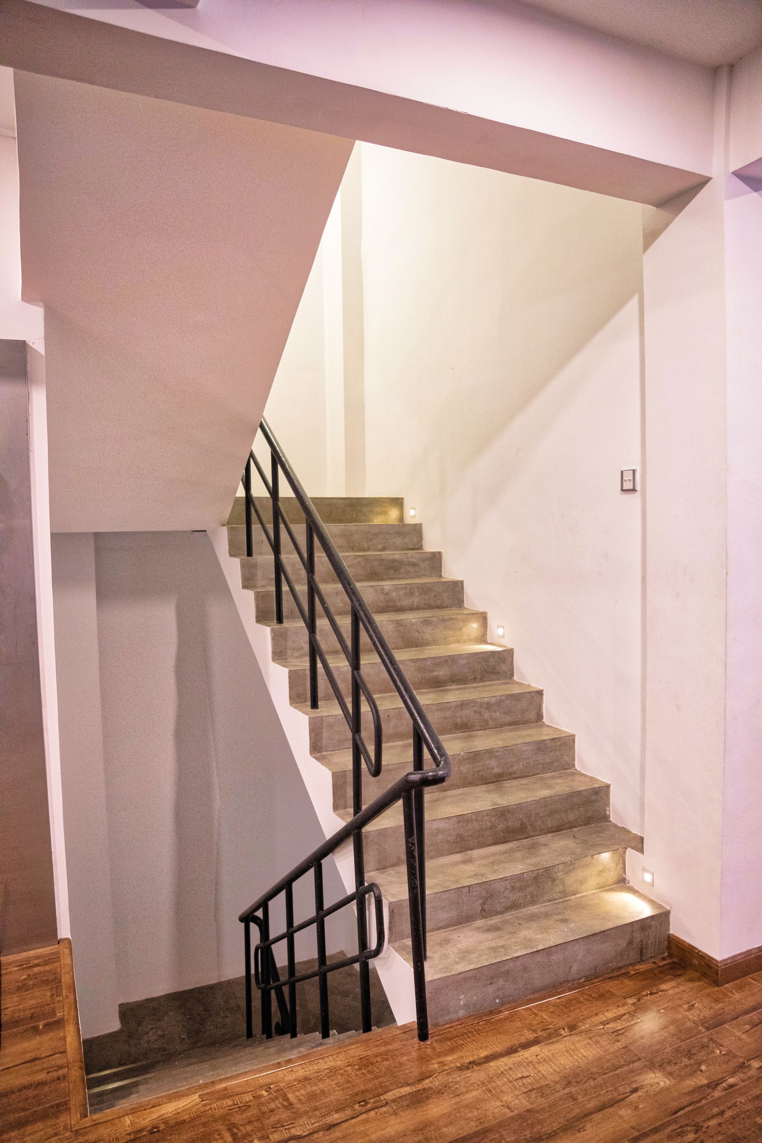 A staircase with a wooden floor and a metal railing.