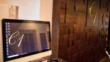 Una computadora de escritorio con un monitor mostrando la barra de tareas de Windows, un teclado y un ratón sobre un escritorio de madera.