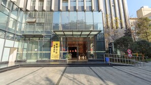 A modern building with large glass windows and a covered entrance. - Chengdu Tu Le Apartment (Chengdu)