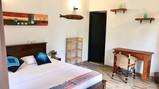 Une chambre à coucher comprenant un lit, une table de chevet, une chaise et une étagère murale décorative.