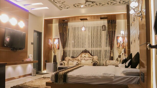 Une chambre moderne avec un grand lit, un téléviseur à écran plat et un plafond décoratif.