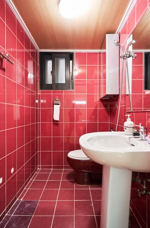 A bathroom with red tiled walls, a wooden ceiling, a white sink, and a shower. - Myeongdong Residence (Seoul)