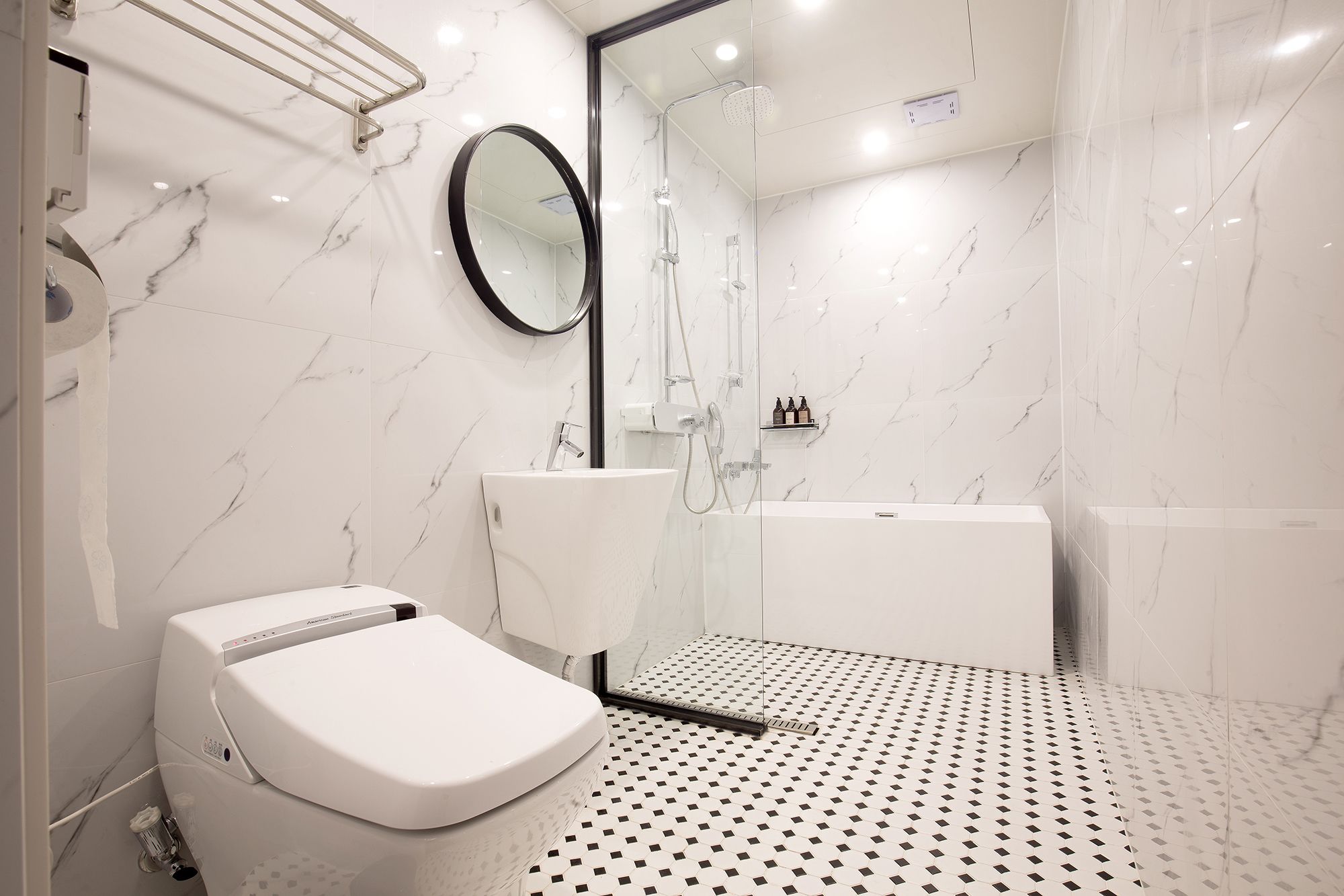 A modern bathroom with a toilet, sink, and shower area.