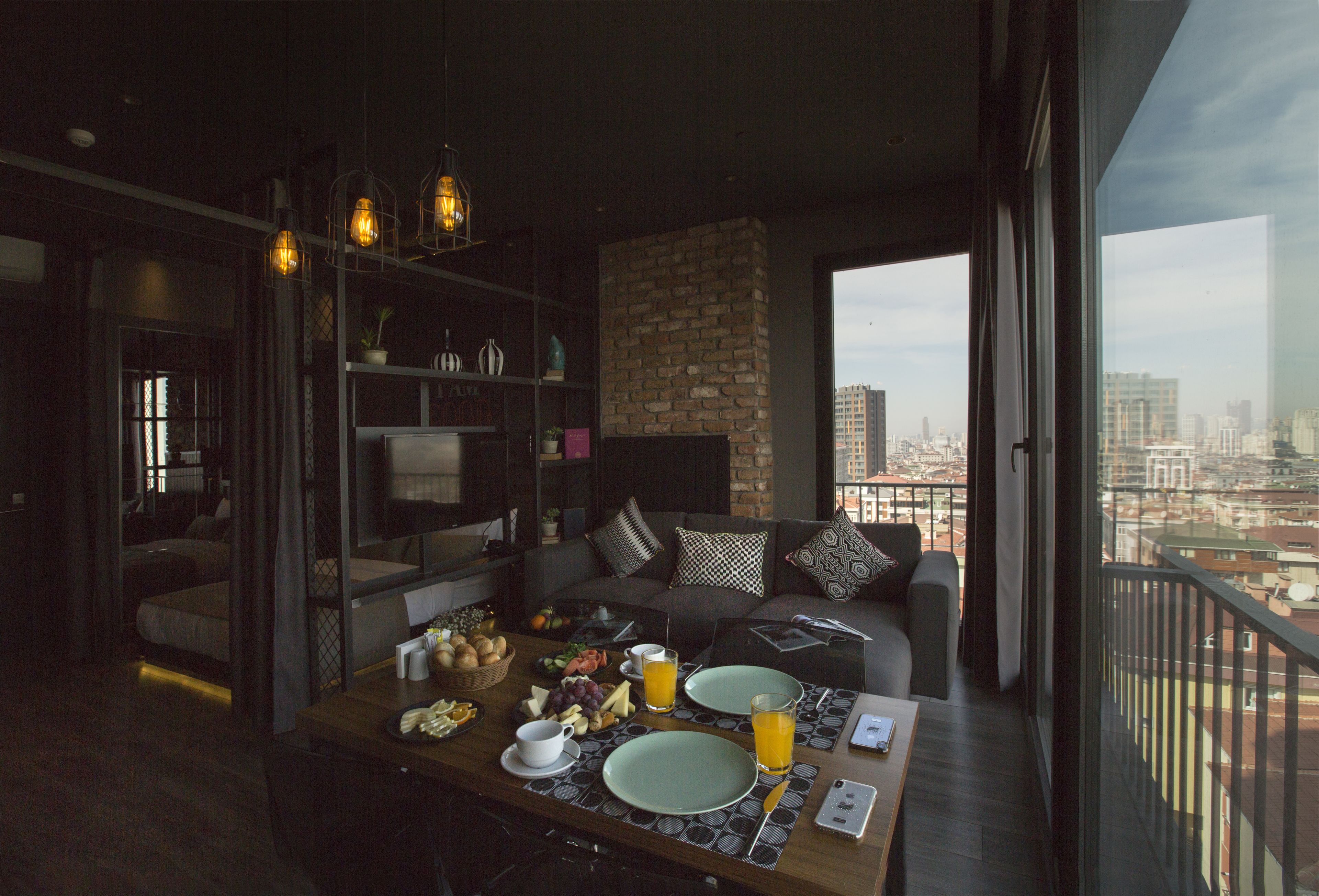 A modern dining area with a city view, a sofa, and a breakfast setup.