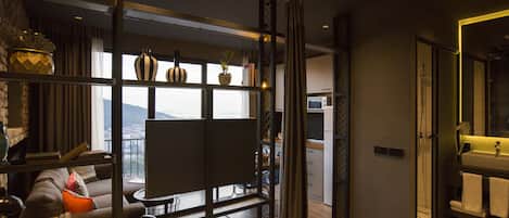 Una sala de estar moderna con un televisor grande, un sofá y un balcón con vistas.