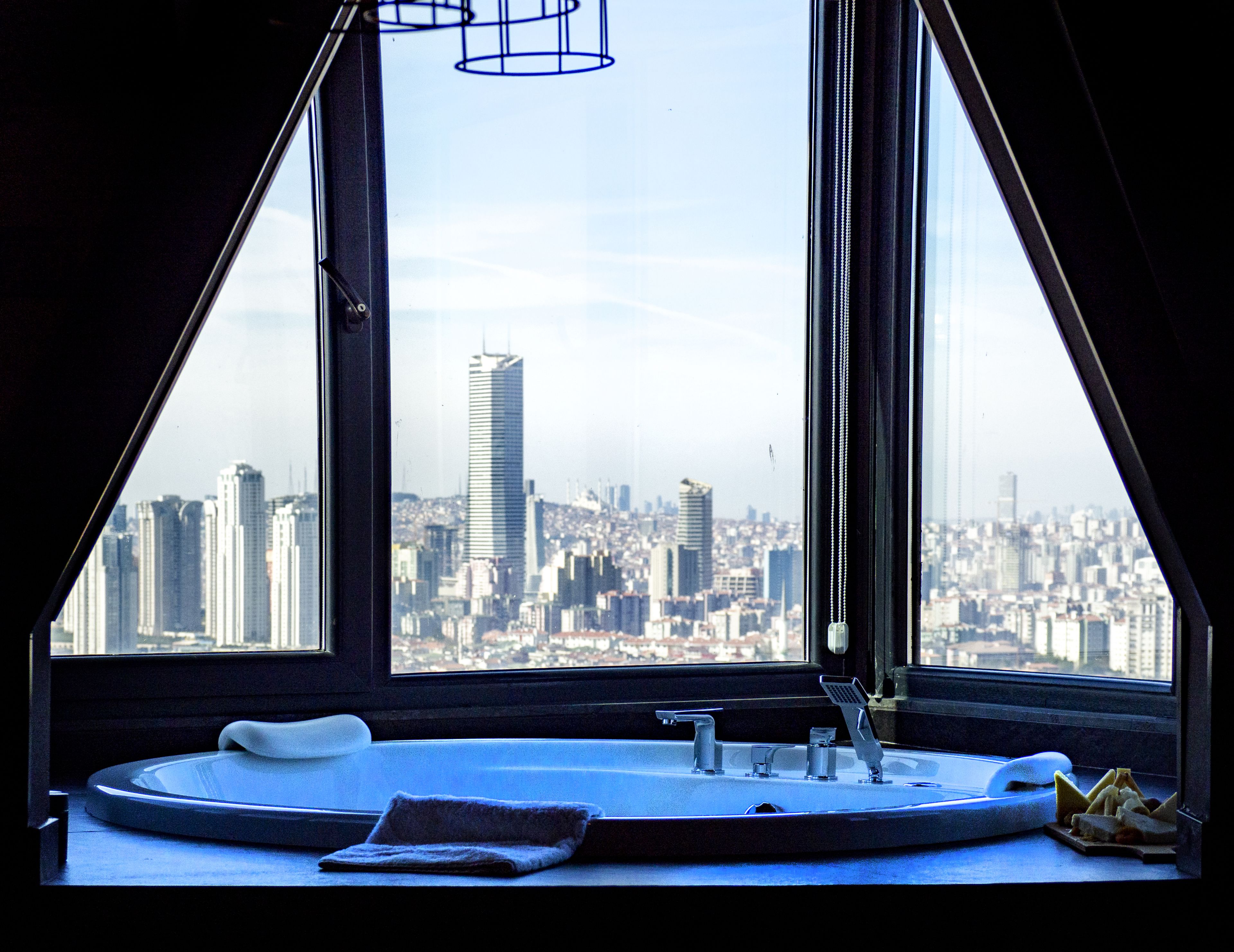 A bathroom with a large window, a sink, and a towel.