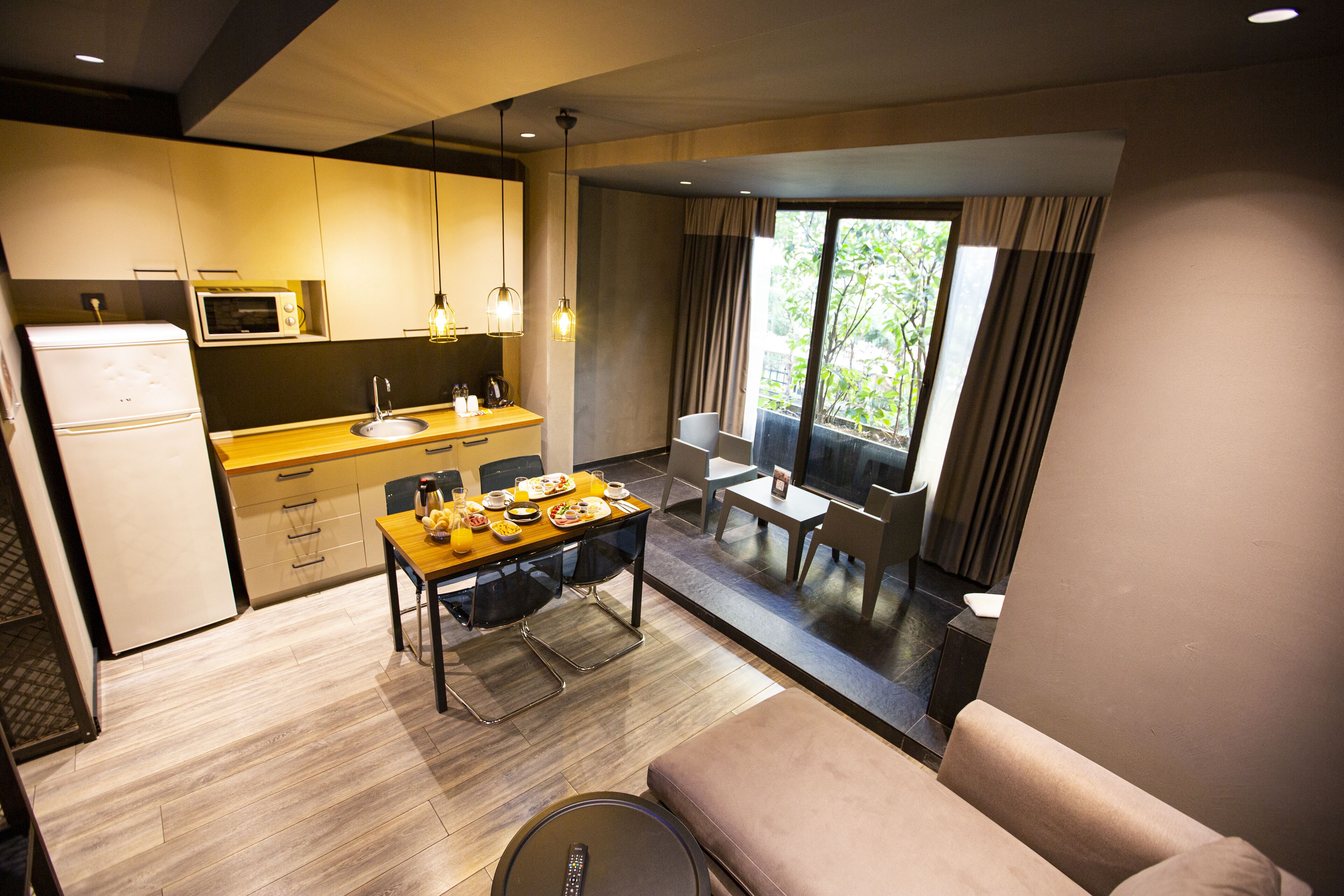 A compact kitchen with a microwave, sink, and dining area with a table and chairs.