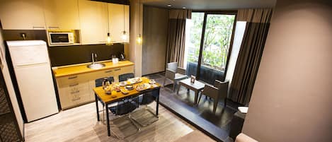 A compact kitchen with a microwave, sink, and dining area with a table and chairs.