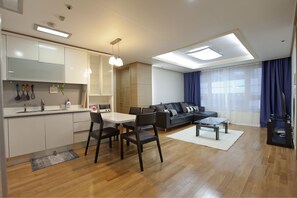 Un salon moderne comprenant un canapé, une table basse et un coin repas avec des chaises et une table.