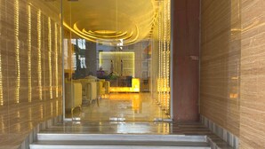 A modern hotel lobby with a marble staircase leading to a reception area.