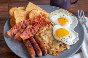 A plate with two fried eggs, bacon, sausages, and toast. - Hotel Valentino (Noakhali)