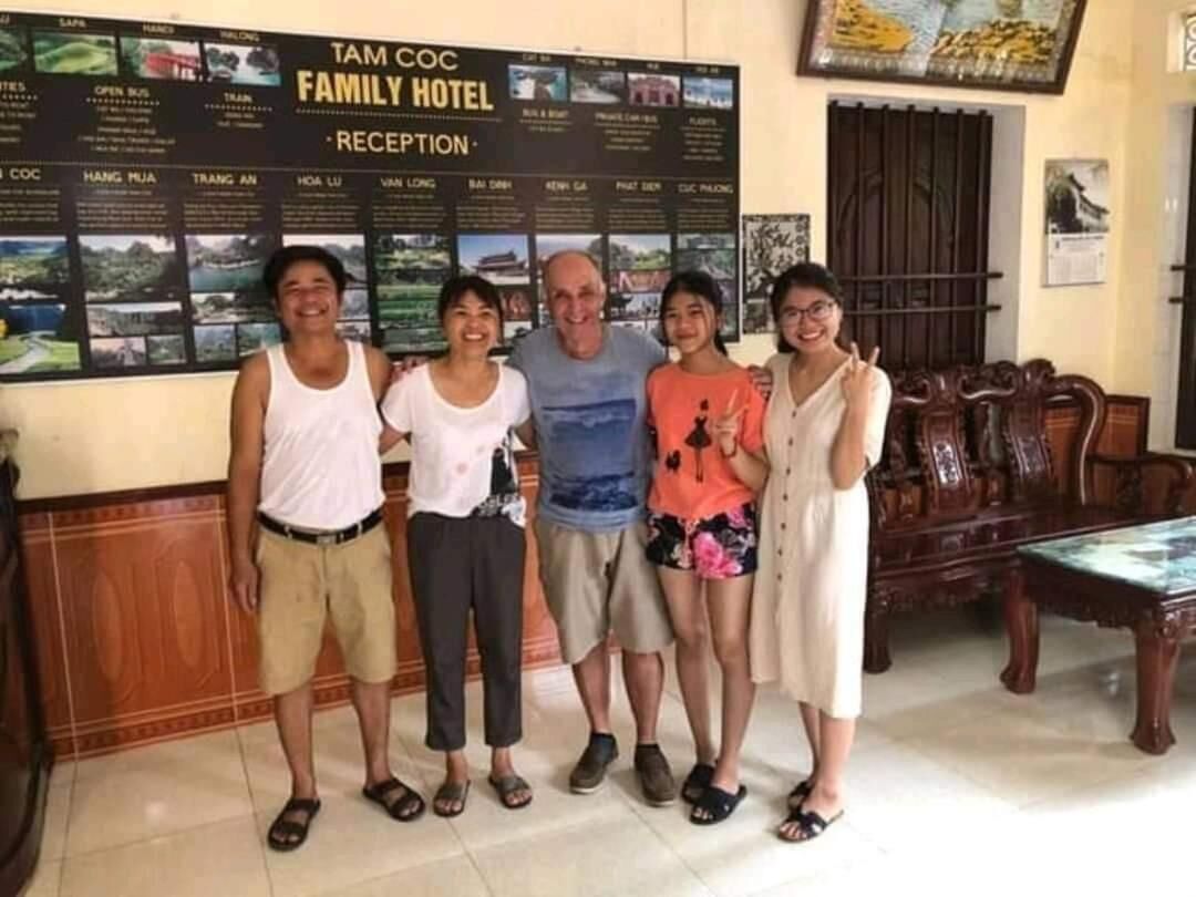 Un espace d’accueil où une famille se tient devant un mur sur lequel sont affichés différents lieux et différents services.