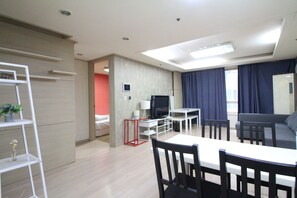 Een moderne woonkamer met een eethoek, een televisie en een bank.