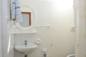 A bathroom with a white sink, a mirror, and a towel hanging on the wall. - Hotel Pensione Elena (Misano Adriatico)