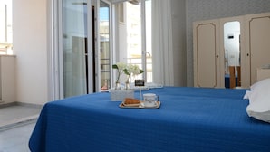 A hotel room with a bed, a coffee tray, a vase with flowers, and a sign that says "Brunch time". - Hotel Pensione Elena (Misano Adriatico)