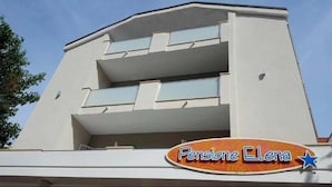 A building with a modern architectural style, featuring a flat roof and a balcony on the second floor. - Hotel Pensione Elena (Misano Adriatico)