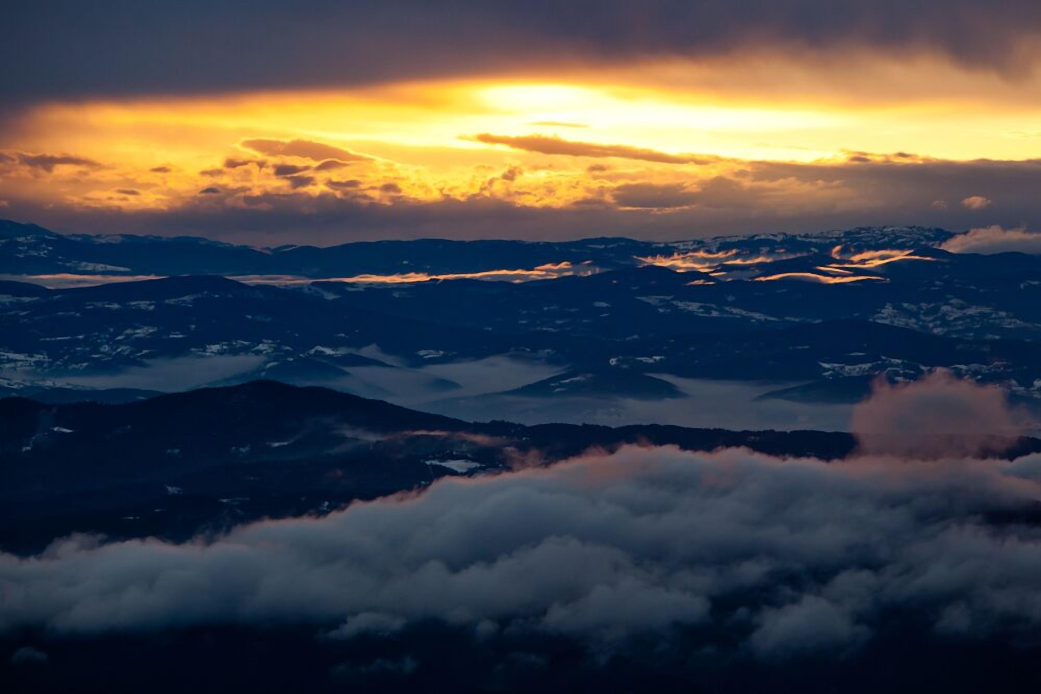 A mountainous landscape with a sunset.