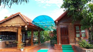 A reception area with a bamboo structure, a reception desk, and outdoor seating. - Tam Coc Rice Fields Homestay (Nam Hoa Lu)