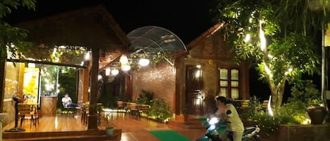 Un restaurante con terraza y zona de estar cubierta.