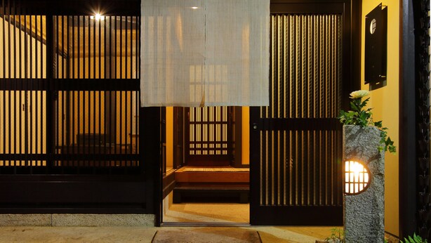 A traditional Japanese entrance with sliding doors and a stone lantern. - Kyo Akari Inn (Kyoto)